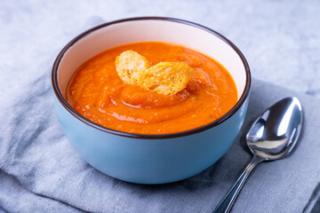 Pumpkin cream soup with croutons in a bowl. Vegetarian homemade soup. Gray background, close-up.