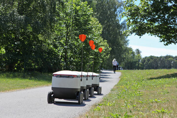 moving delivery robots on the street. crossing the road with a pedestrians. Cyber-couriers are cruising the sidewalks in Estonia. Copy space for design. Modern delivery concept- robots delivery.