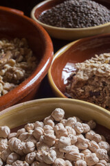 Close-up of a handful of chickpeas with an unfocused background of assorted cereals and legumes.