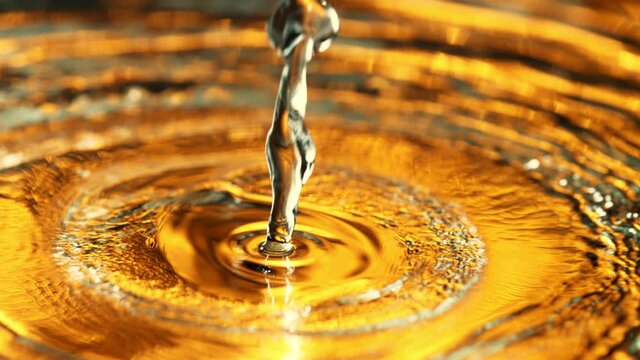 Super Slow Motion Shot of Pouring Liquid on Golden Luxury Background at 1000 fps.