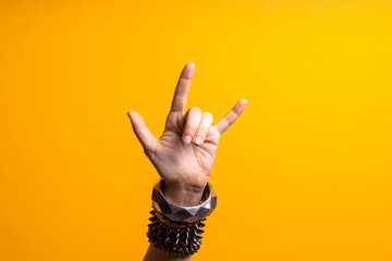 Hand gestures. Thumbs up, that's a cool gesture of the rocker. women's hand with lots of bracelets,...