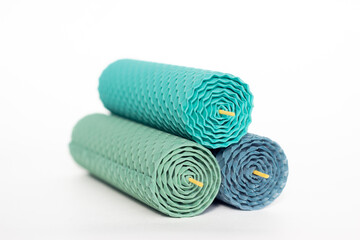 Close up of three natural decorative beeswax candles with lace ribbons and a honey aroma for interior isolated on a white background. A delicate color palette. Handmade