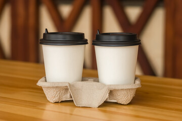 Coffee to go. Two white paper cups with a blank space for the logo.