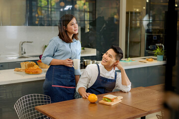 Feel good atmosphere of a couple eating inside the kitchen background..