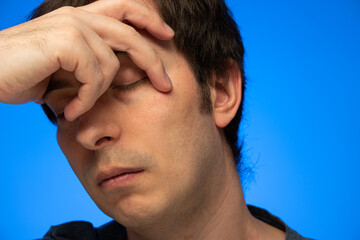 Caucasian male head in hand pensive worried depression look closed eyes close up studio shot