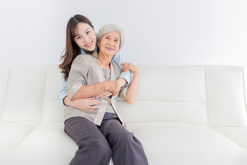 close up old woman, young Asian female hug old female in home, they feeling happy and smile, they sitting on sofa, mother's day, happiness elderly in family time