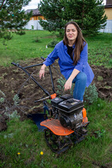 young woman in the garden with a walk-behind tractor