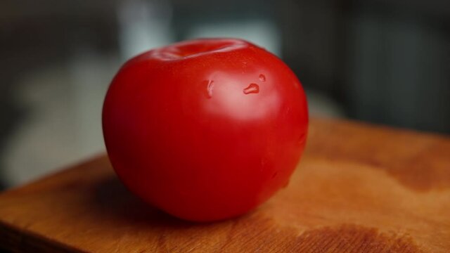 woman in black gloves cuts tomatoes at home close up