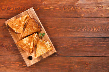 Thin pancakes from Russian cuisine. Russian blini, crepes on a wooden background. Shrovetide holiday. Pancake week. Top view.