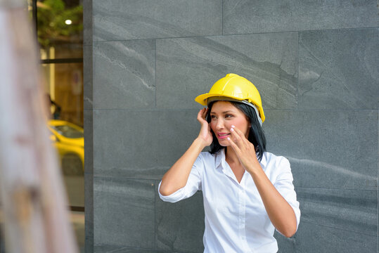 smart woman Exterior designer smiling and removing construction helmet.