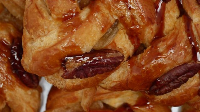 Close Up Of Top View Pastries With Roasted Pecan And Maple Syrup Rotating On The White Plate.