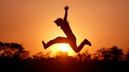 Fototapeta na wymiar Man Jump with joy silhouette time of sunset