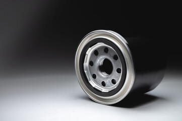 New oil filter in a black housing on a gradient gray background. New spare parts