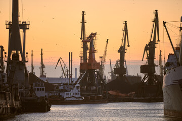 Ships in sea port on sunset background