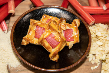 A delicious desert of rhubarb squares surrounded by the ingredients used to create the snack