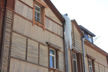 frozen water on the roof of an old wooden house
