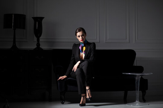 photo of stylish caucasian woman sittin on black sofa