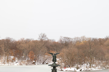 Angel on top of the Bethesda Fountain by the Lake at Central Park during Winter with Snow and Ice...