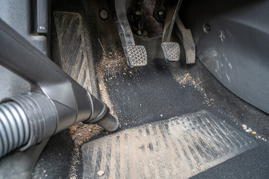 Reinigung eines sehr verschmutzten Fu&szlig;raums eines Autos mit dem Staubsauger