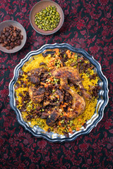 Traditional fried Arabic chicken majboos with chicken leg and jeweled rice served as top view in a...