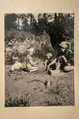 Germany - CIRCA 1930s: Group photo of mother and tree small kids sitting in garden. Vintage archive Art Deco era photography