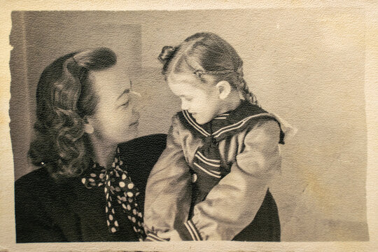 Germany - CIRCA 1940s: Portrait of happy mother and daughter sitting in studio. Vintage Carte de Viste Art Deco era photo