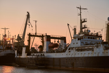 Ships in sea port on sunset background