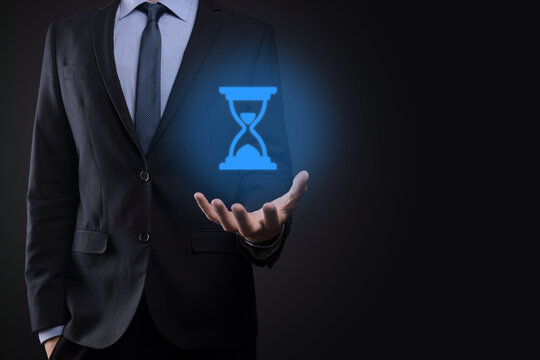 Businessman man holds in hand hourglasses icon. Time expires. A reminder to action. Business concept. Elements for design.