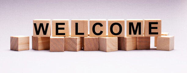 On a light background, wooden cubes with the text WELCOME