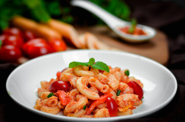 Pasta with spicy tomato sauce and basil and sausage.