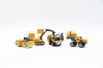 Construction site work vehicles on white background with copy space.