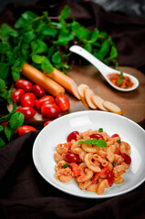 Pasta with spicy tomato sauce and basil and sausage.