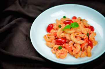 Pasta with spicy tomato sauce and basil and sausage.