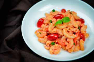 Pasta with spicy tomato sauce and basil and sausage.