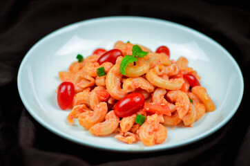 Pasta with spicy tomato sauce and basil and sausage.