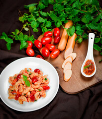 Pasta with spicy tomato sauce and basil and sausage.