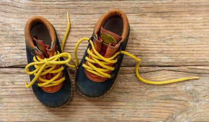 Baby shoes on wood, closeup view, child booties blue and yellow color