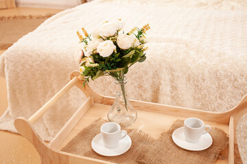 interior, tray with coffee cups, flowers in a vase. Breakfast.