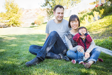 Happy Mixed Race Family Having Fun Outside on the Grass