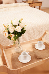 Fototapeta na wymiar interior, tray with coffee cups, flowers in a vase. Breakfast.