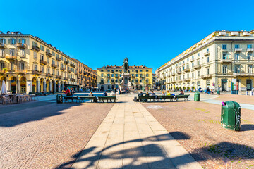 Fototapeta na wymiar Turin, Italy. March 1st, 2021. Piazza Gianbattista Bodoni with the Equestrian statue of General Alfonso Ferrero della Marmora in a March sunny day with young people sitting on the benches.