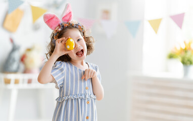 child with Easter painting eggs