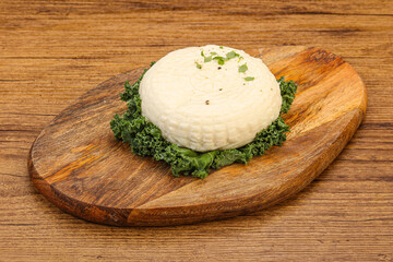 Caucasian suluguni round cheese piece