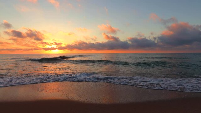 Dramatic sea sunrise. Burning sky and shining golden waves, 4k video