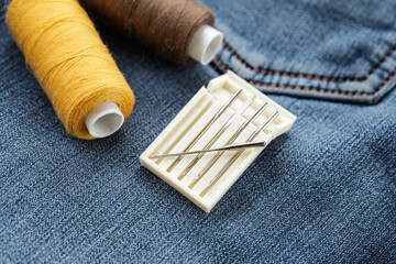 Needle and Thread on jeans texture. Denim fabric. Close up