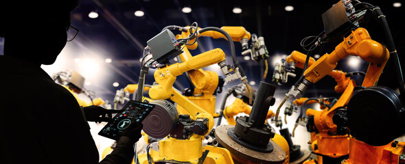 Factory Female Industrial Engineer working with automation robot arms machine in intelligent factory industrial on real time monitoring system software.Digital future manufacture.