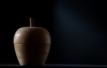 wooden apple against dark background ,studio style shot.concept healthy eating .