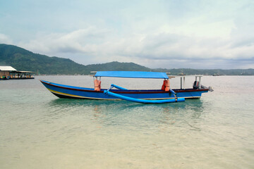 Traditional fishing boats moored by the sea on Condong Island, Lampung, Indonesia, in the afternoon.