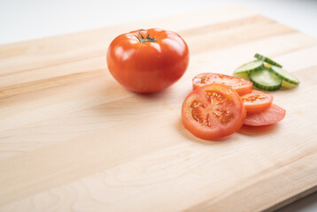 Sliced Tomato and Cucumber on wooden cutting board