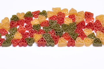 Italian three color heart shaped pasta on white background with copy space